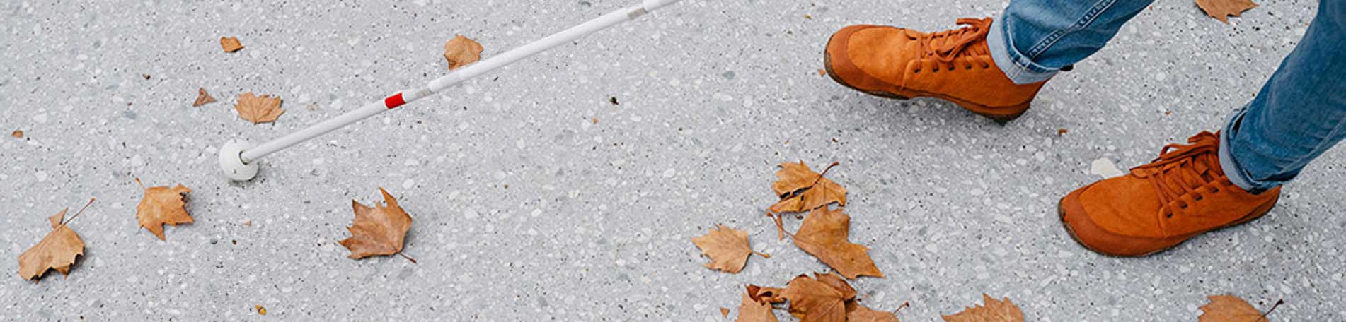 Füße einer Person, die mit Langstock läuft